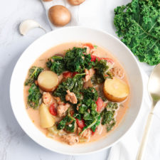 a bowl of creamy sausage kale soup with potatoes