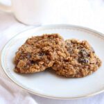 two healthy oatmeal cookies on a small white plate
