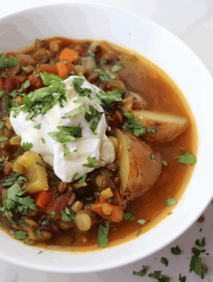 lentil potato soup with a dollop of yogurt and a sprinkle of fresh cilantro leaves.