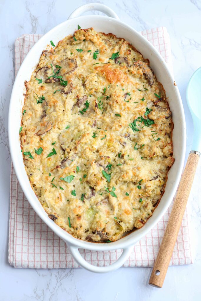 creamy chicken and mushroom cauliflower rice casserole baked on a kitchen towel in a white oval casserole dish