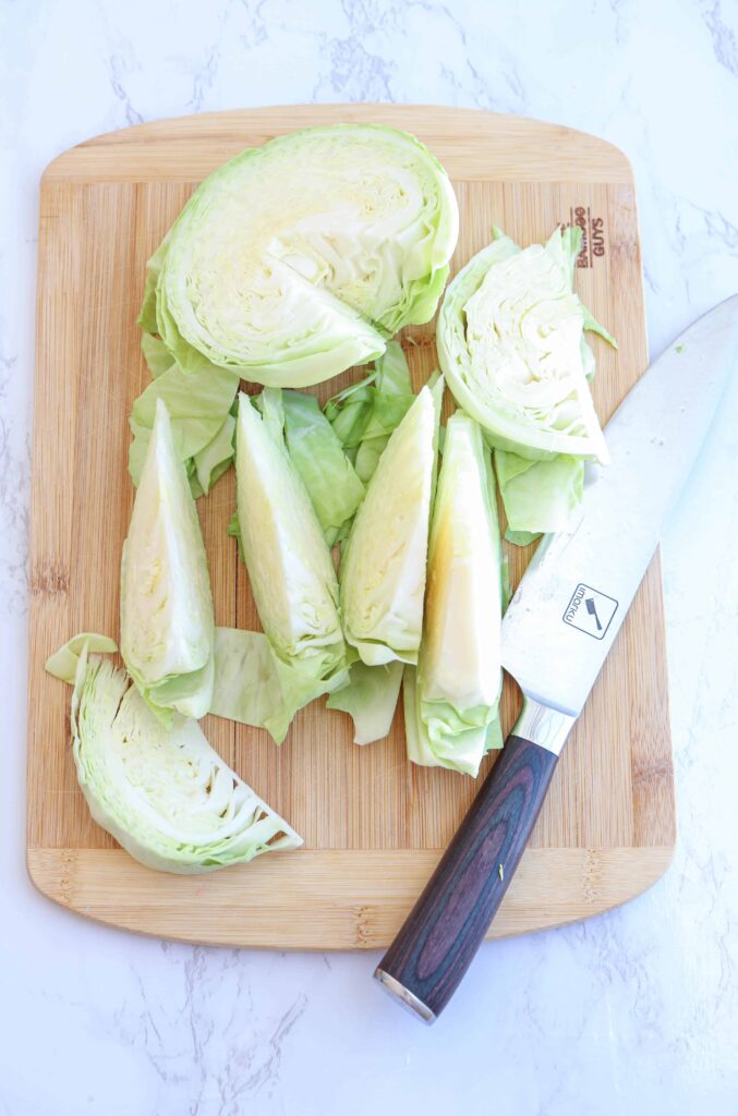 cabbage cut into wedges on a chopping board