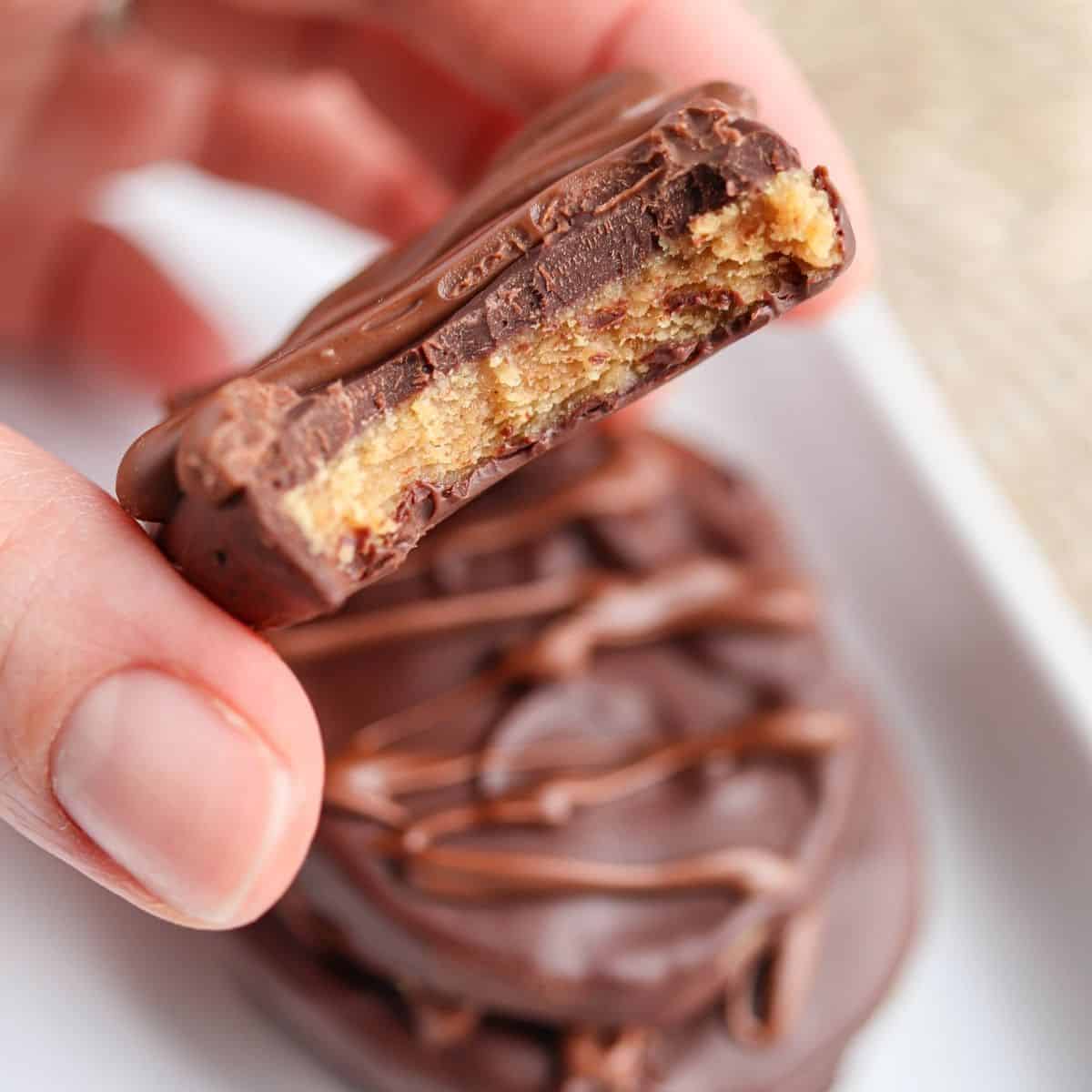 a stack of peanut butter eggs in chocolate with one egg bitten to show texture