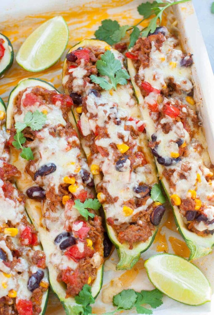 taco stuffed zucchini boats with beans, corn, meat and cheese.