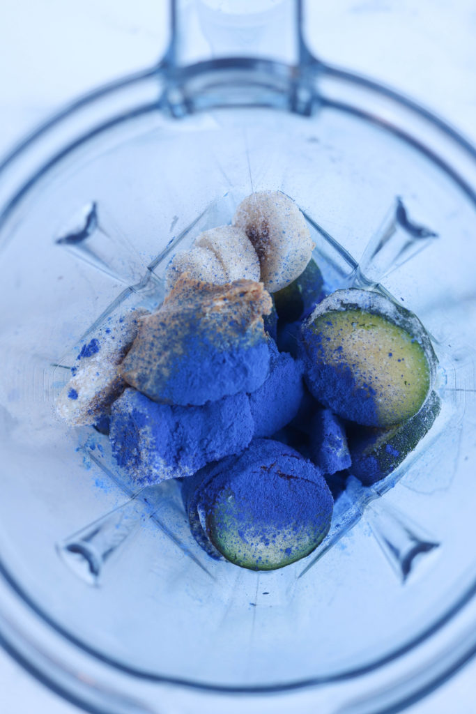 frozen zucchini, bananas and blue spirulina powder in a blender bowl
