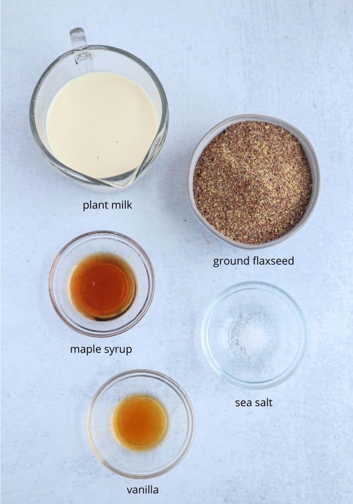 flaxseed pudding ingredients laid out on light gray surface in small round bowls with captions