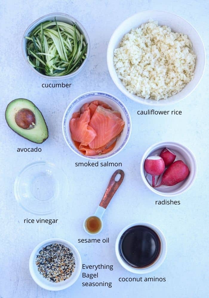 low carb sushi bowl ingredients laid out in round containers on gray surface
