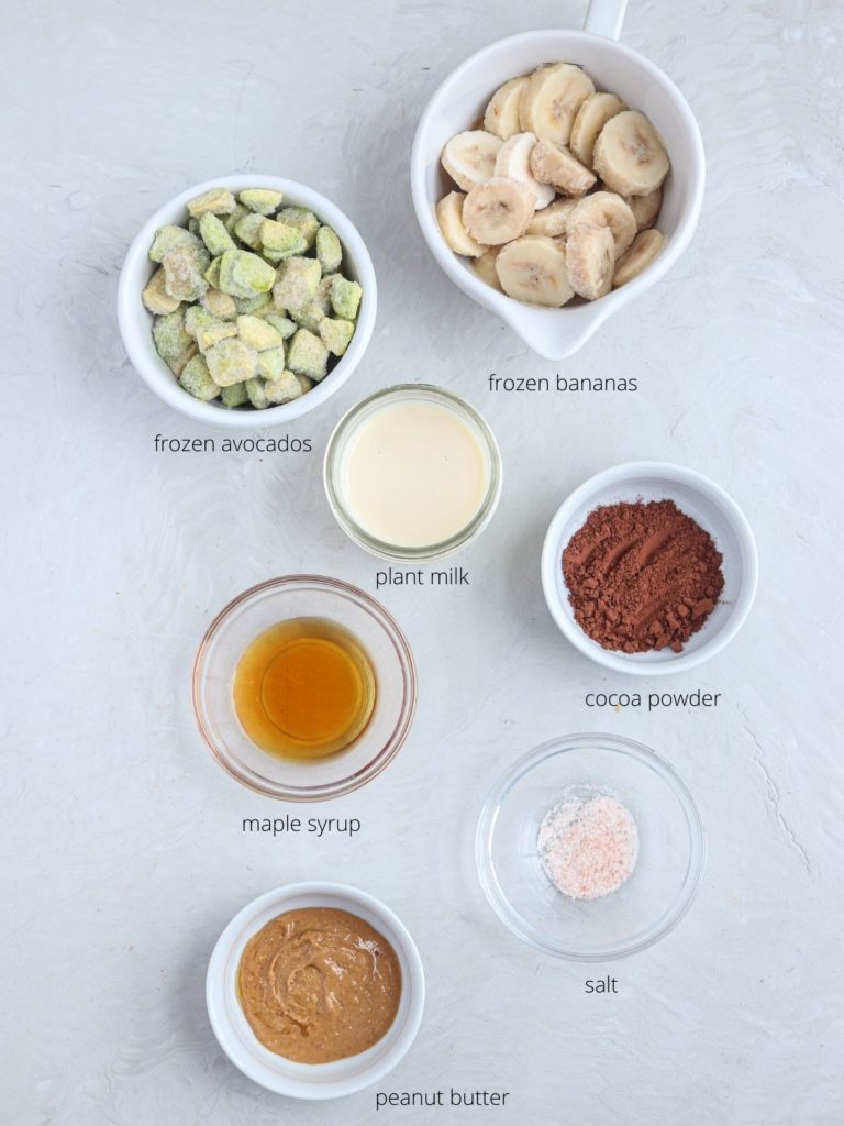 snickers smoothie bowl ingredients laid out on light gray surface.
