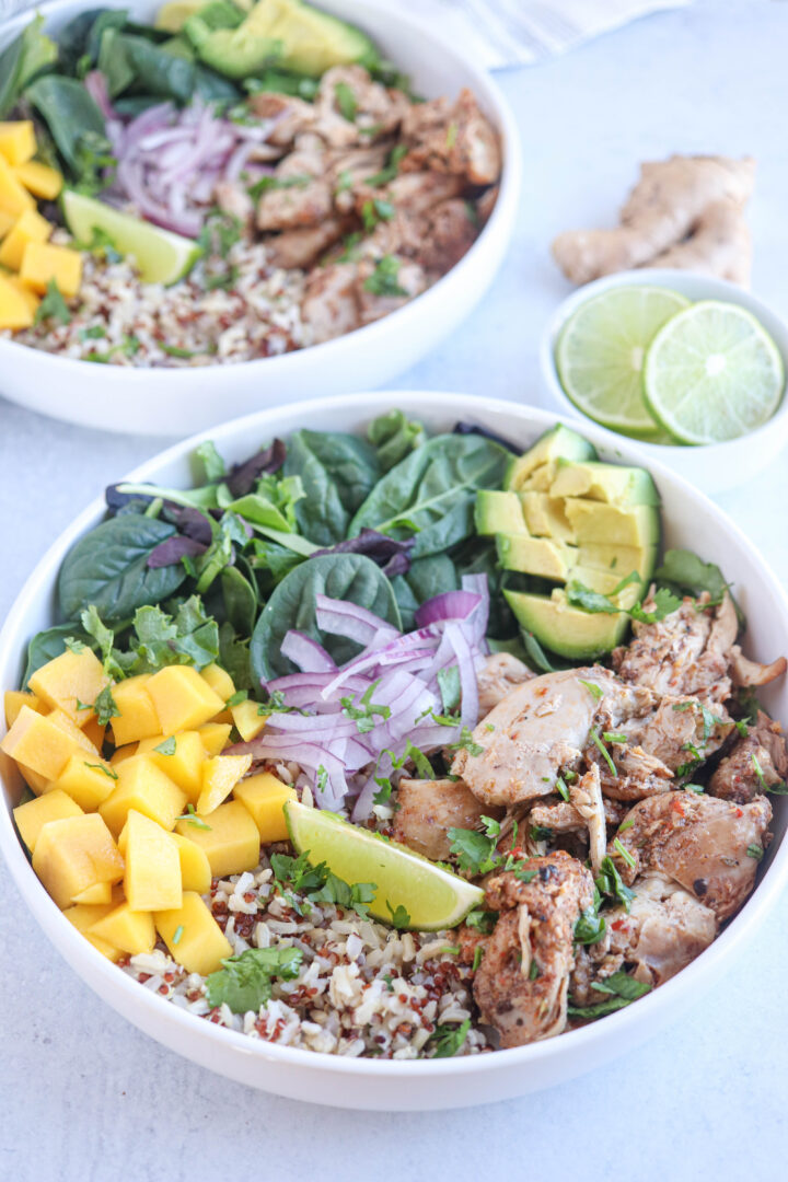 jerk chicken rice bowl with diced mango, greens, avocado, red onions and lime.