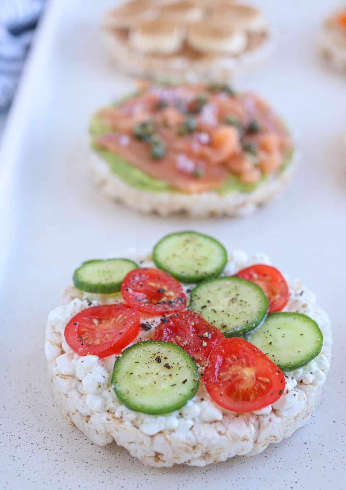 rice cake topped with cottage cheese, tomato, cucumber, salt and pepper.