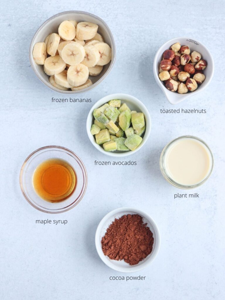 nutella smoothie bowl ingredients in small containers on a light gray surface.