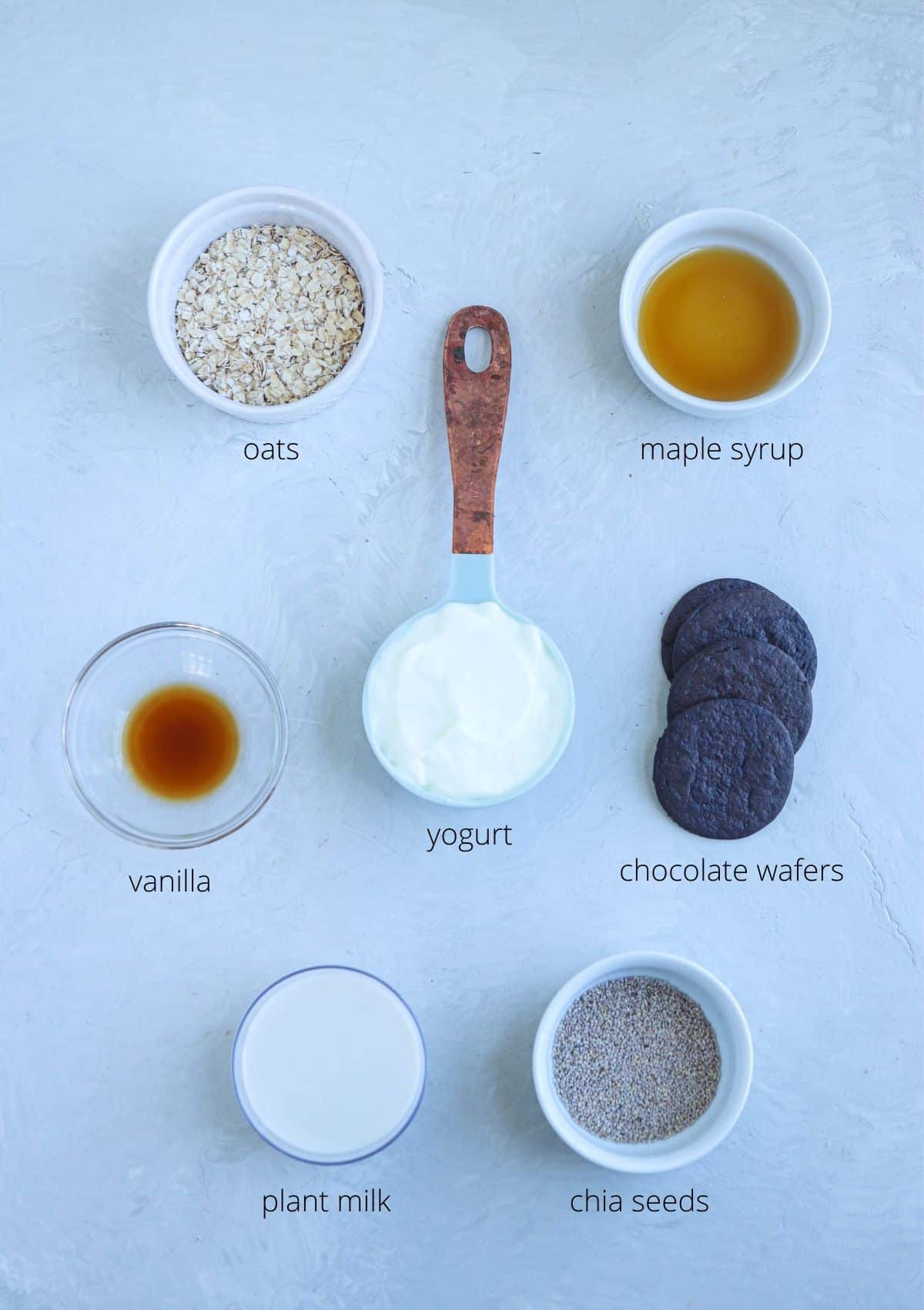 oreo overnight oats ingredients in small round containers laid out on light gray surface with captions.