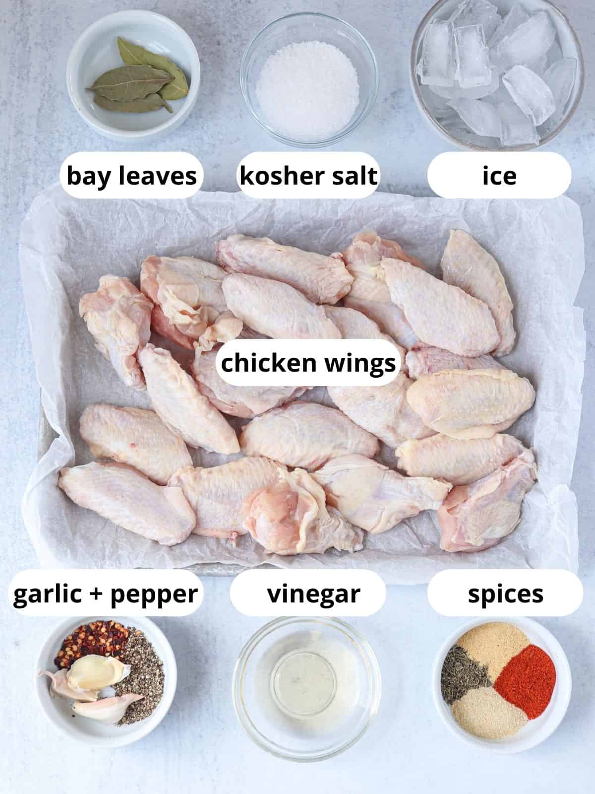 ingredients for brined chicken wings in containers on light gray surface.