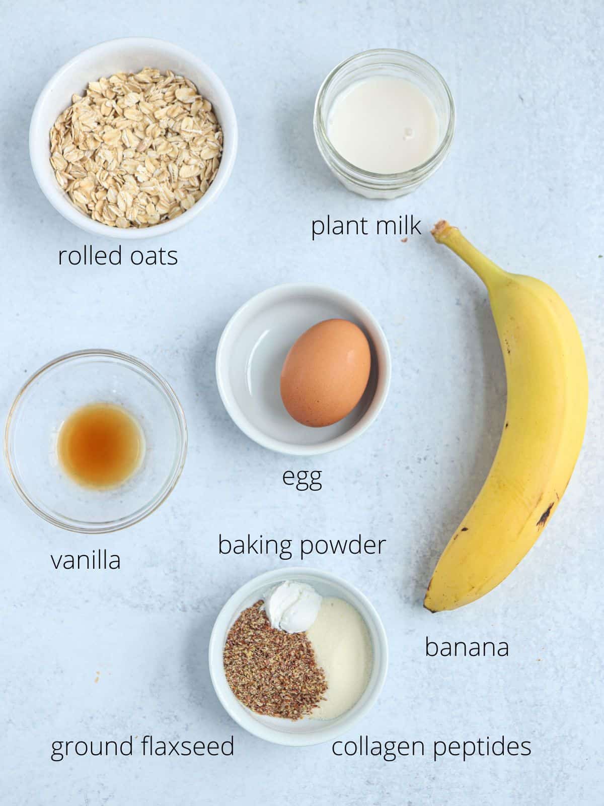 healthy protein banana pancakes ingredients in small round containers with captions.