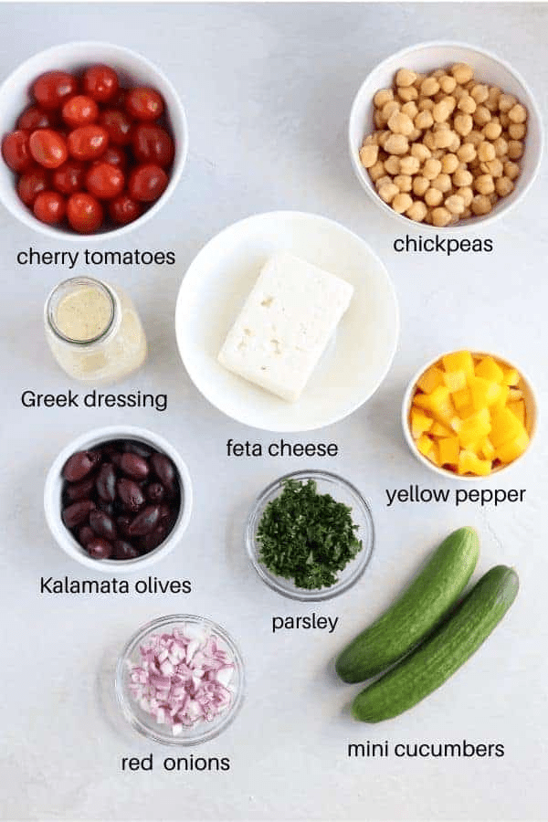 Greek chickpea salad ingredients in round containers on light gray surface with captions.