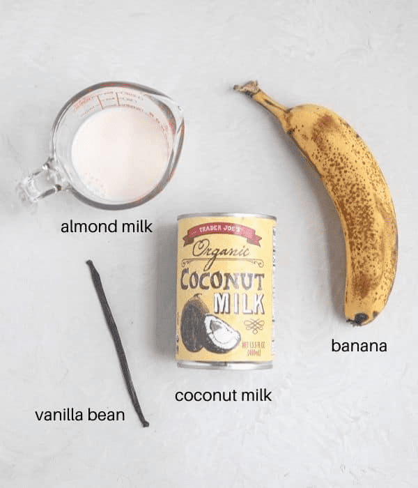 ingredients to make coconut smoothie bowl on light gray surface with captions. 