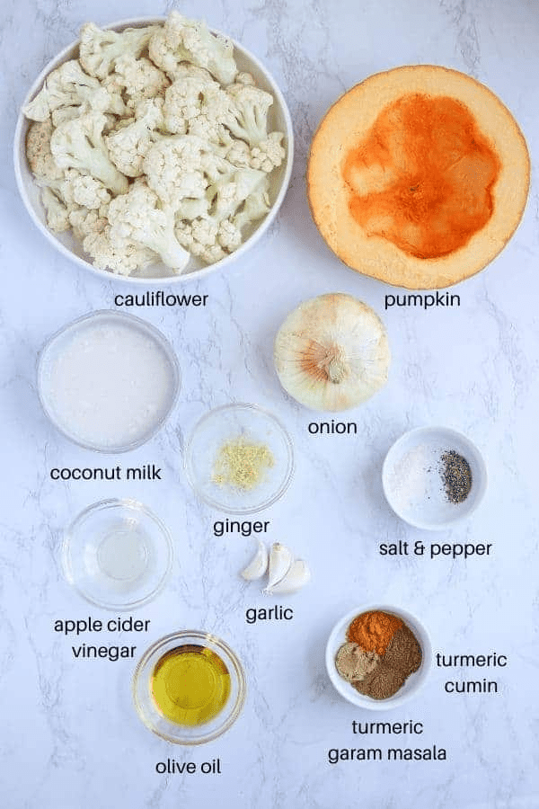 ingredients for pumpkin cauliflower soup on white marble surface with captions. 
