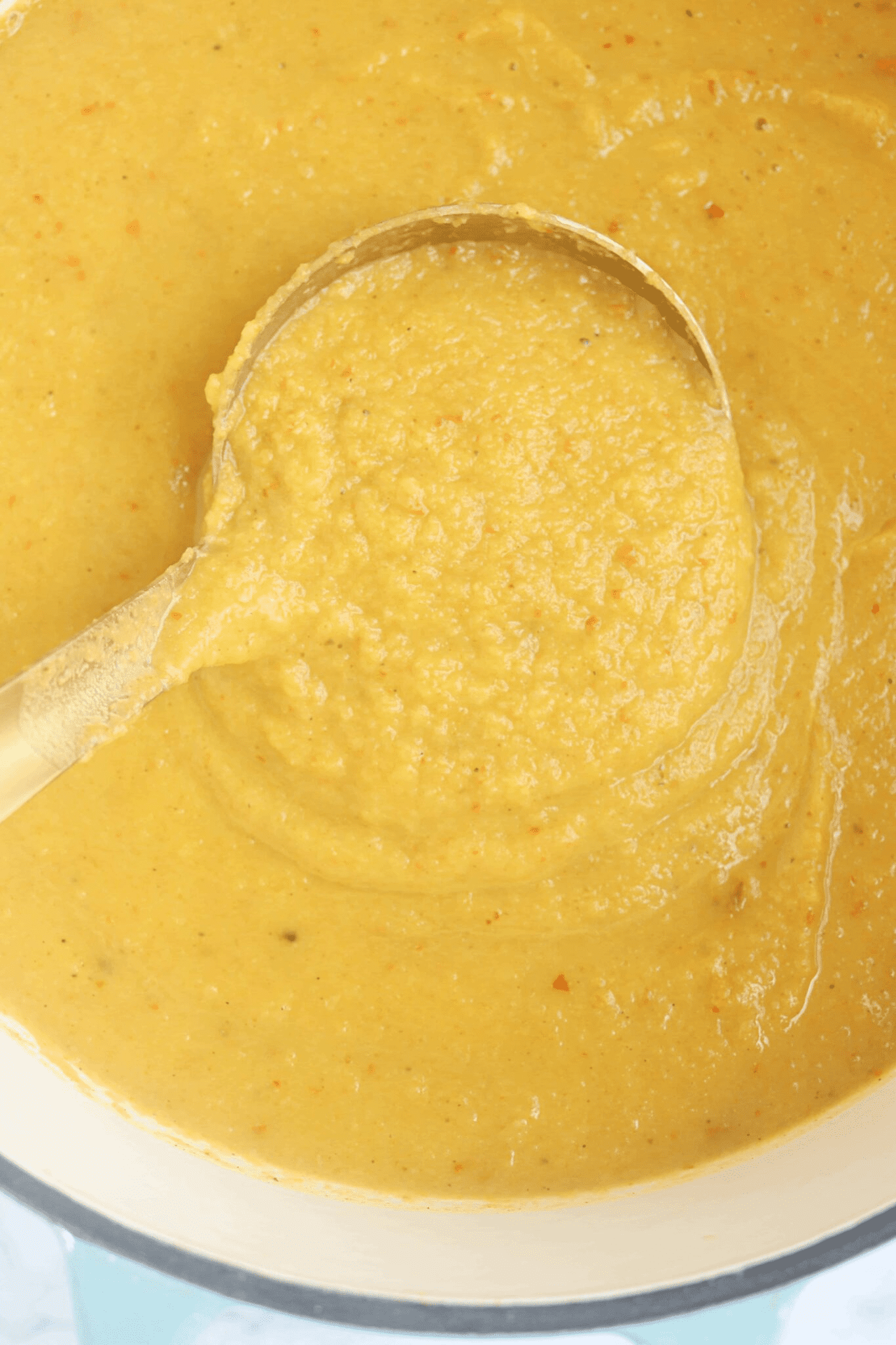 pumpkin cauliflower soup close up with a ladle.
