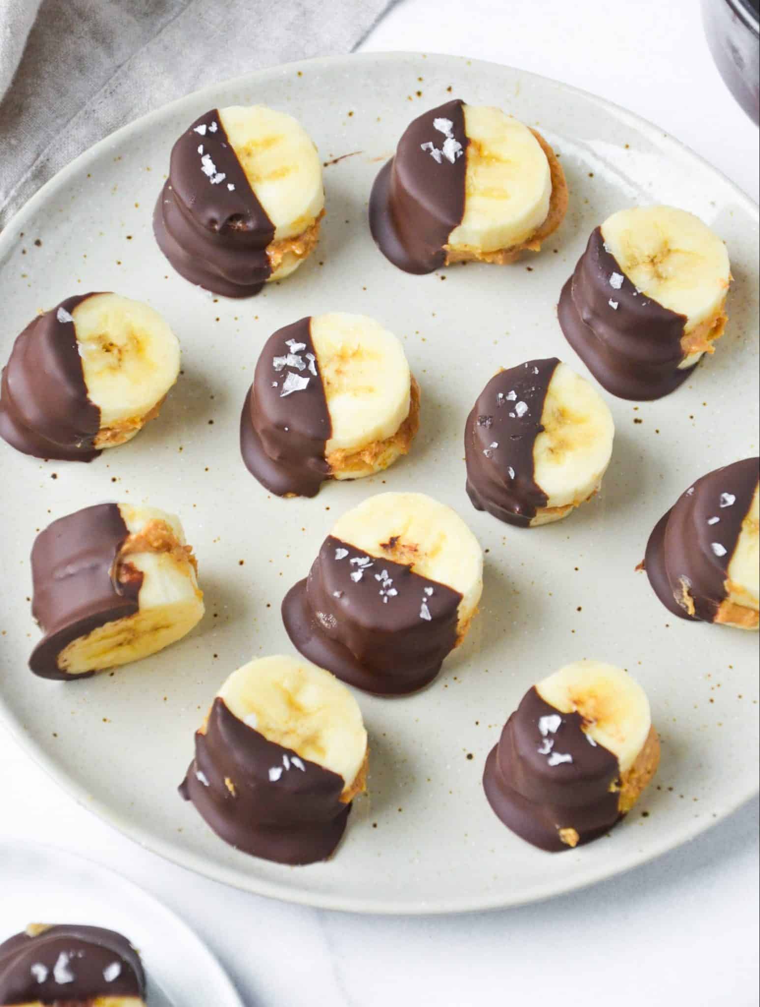 banana bites with peanut butter and chocolate on a round plate.