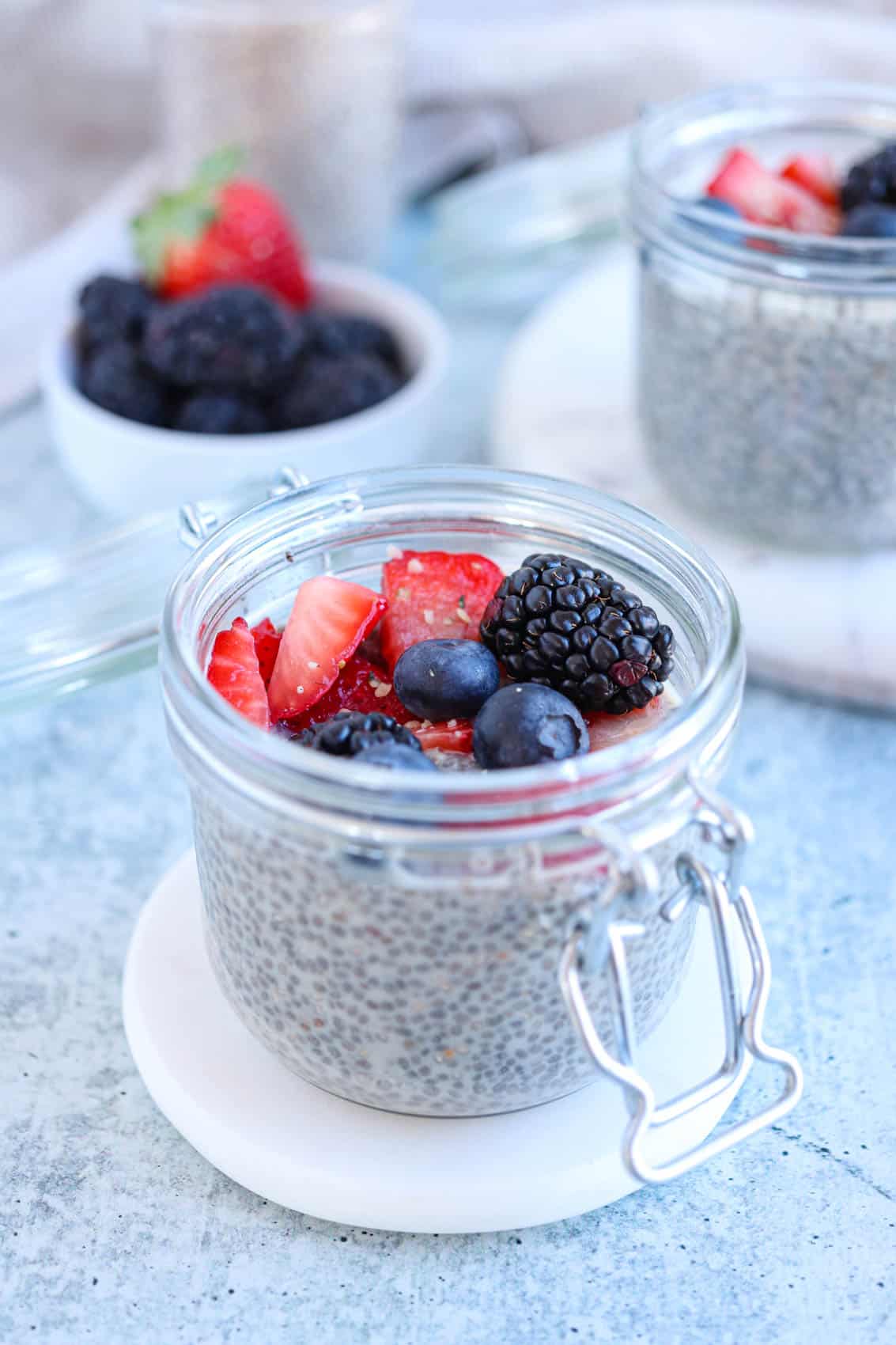 chia pudding topped with berries in a small mason jar.