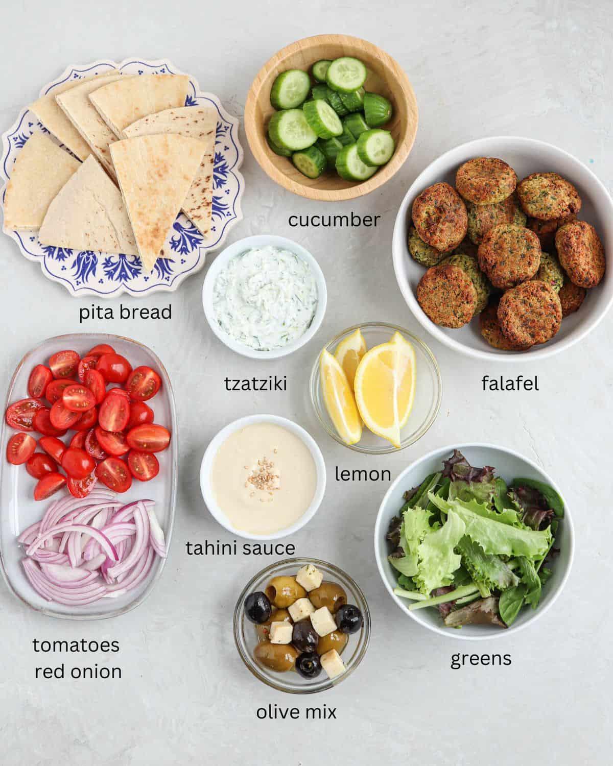 ingredients for making falafel platter in bowls and containers on gray surface with captions.