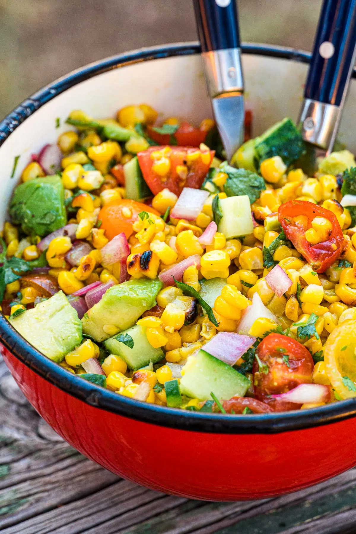 grilled corn salad in a red bowl.