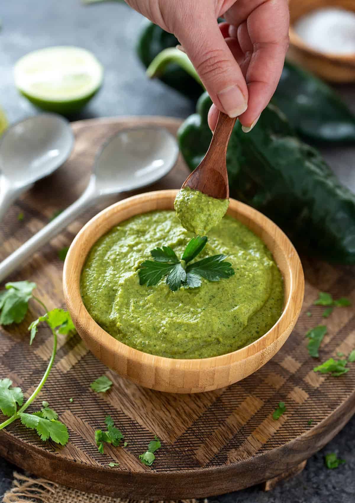 poblano sauce in a wooden bowl on a wooden board.