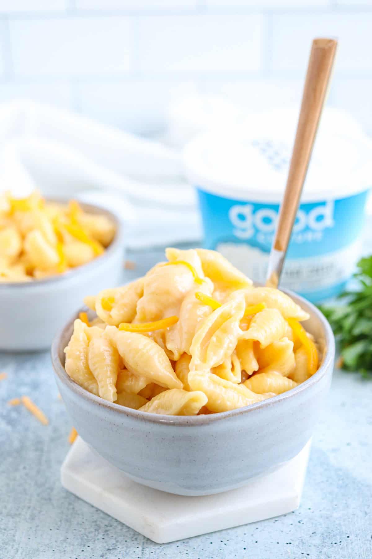 creamy mac and cheese in a small greay bowl on gray background.